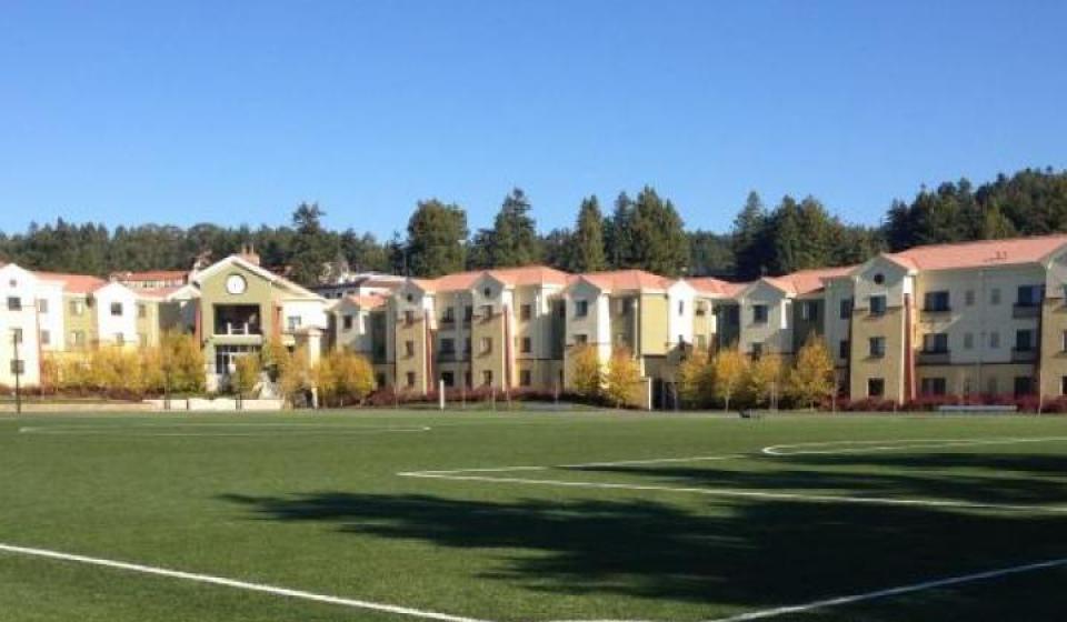 Turf soccer field with College Creek Residence Halls behind it